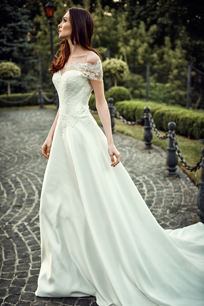 Красивая молодая женщина позирует в свадебном платье - Фото, изображение