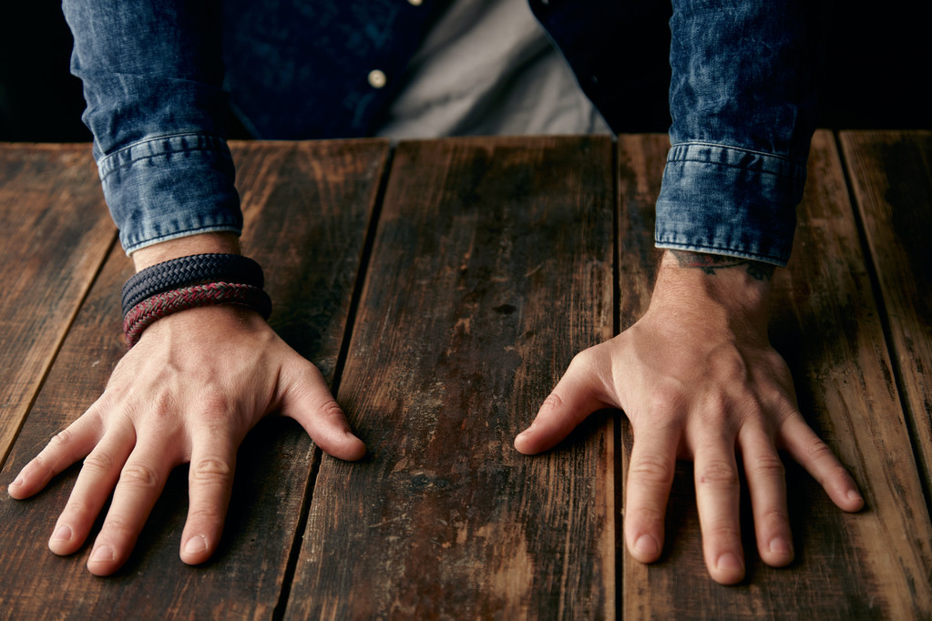 Belle mani di uomini sul tavolo, jeans camicia casual
 - Foto, immagini