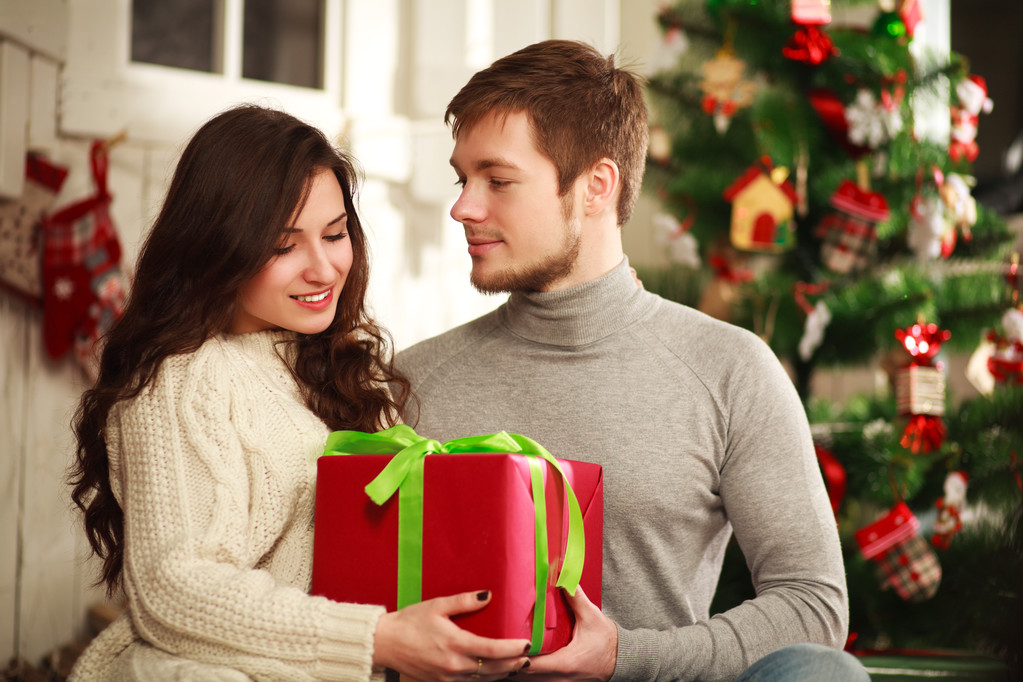 Happy couple with gift at home on a background of the Christmas  - Photo, Image
