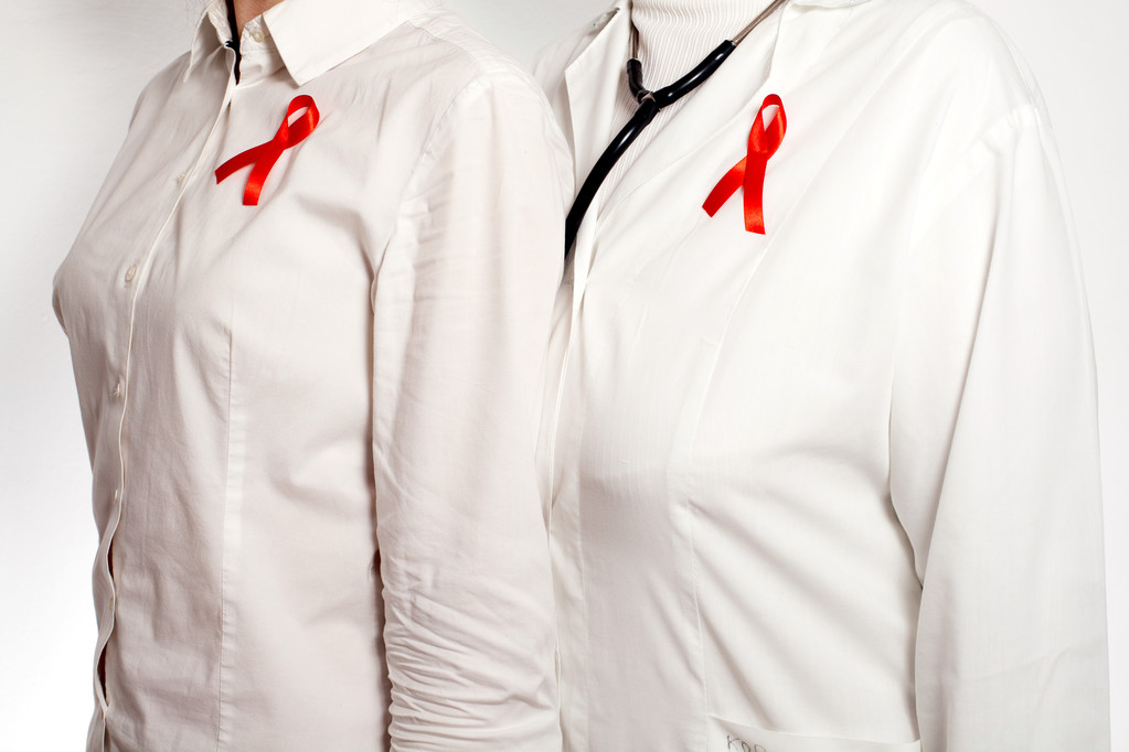 Médico y paciente con cintas rojas de conciencia sobre el SIDA en el pecho
 - Foto, imagen