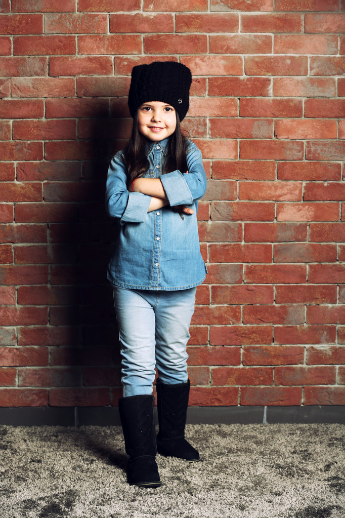 Retrato de niña de moda sobre fondo de pared de ladrillos
 - Foto, imagen