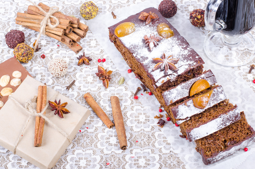 Chcolate spices cake with star anise and dried fruits, cinnamon, cloves, cardamom, handmade milk chocolate with nuts, mulled wine on sackcloth, canvas.  - Photo, Image