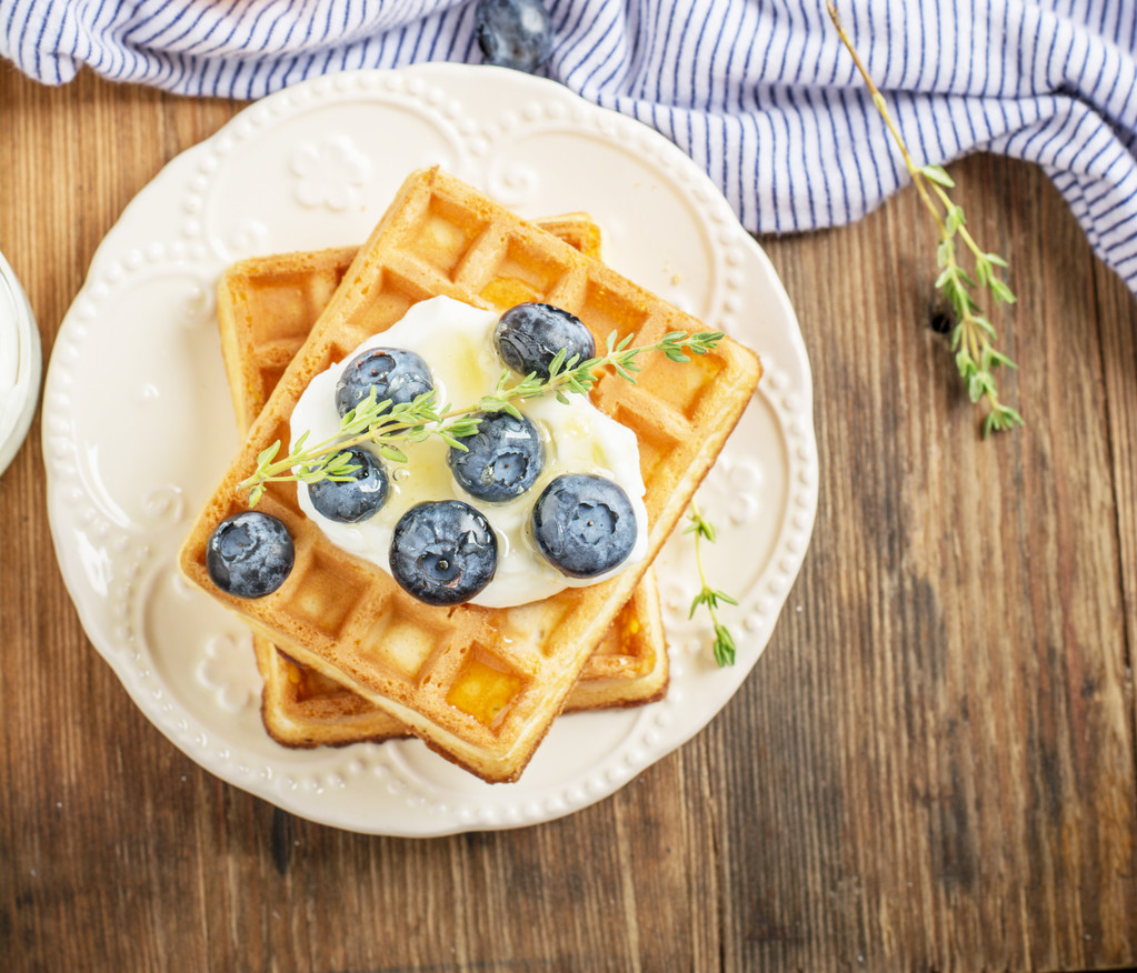 Belgian golden waffles for breakfast with fresh berries and flower honey on wooden background. The concept of home-cooked breakfast.  - Φωτογραφία, εικόνα