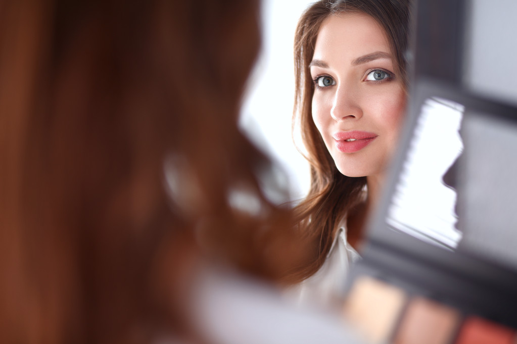 Young beautiful woman making make-up near mirror - Photo, Image