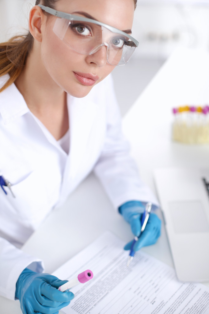 Femme chercheuse entourée de flacons et flacons médicaux, isolée sur fond blanc - Photo, image