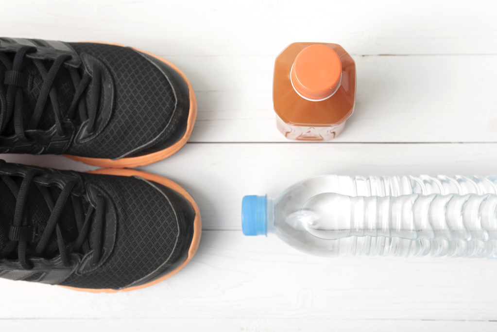 tênis de corrida, água potável e suco de laranja
 - Foto, Imagem