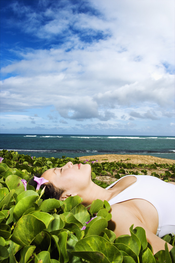 ビーチ近くの植物で横たわる女 - 写真・画像