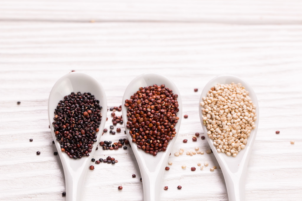 rote, schwarze und weiße Quinoa-Samen auf hölzernem Hintergrund, gesunde Ernährung. - Foto, Bild