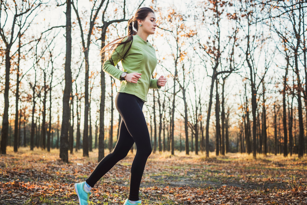 Mulher a correr no parque. Jovem jogging mulher na floresta de outono
 - Foto, Imagem