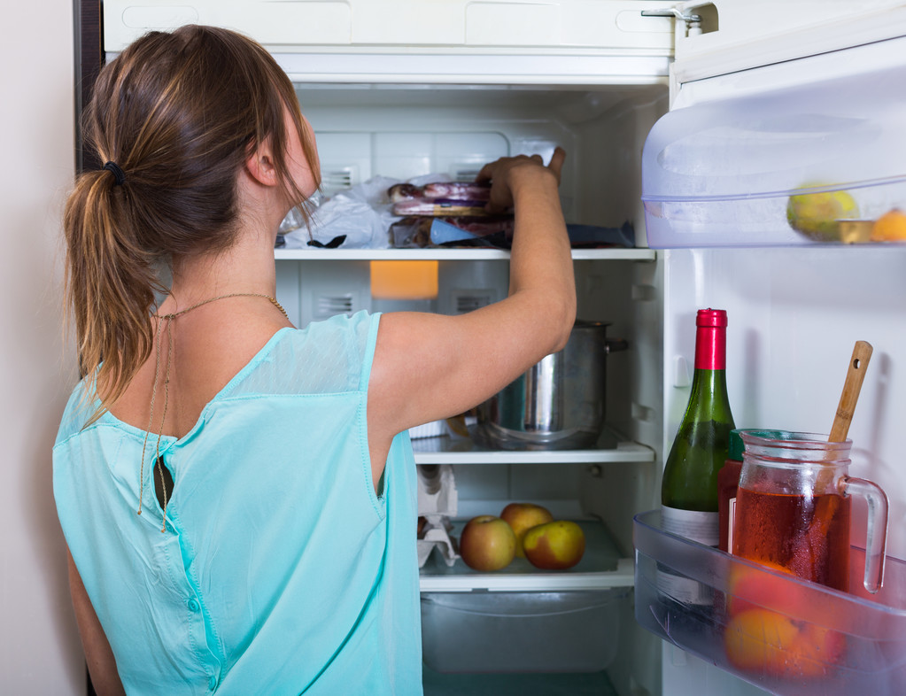 Γυναίκα κοντά σε πλήρη ψυγείο - Φωτογραφία, εικόνα