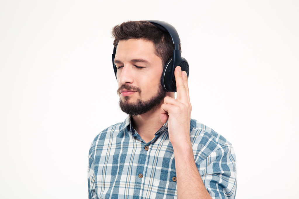 Relajado joven reflexivo escuchando música usando auriculares
  - Foto, Imagen