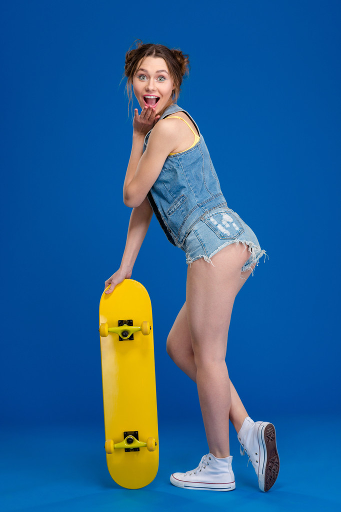 スケート ボードで陽気な女性の完全な長さの肖像画 - 写真・画像