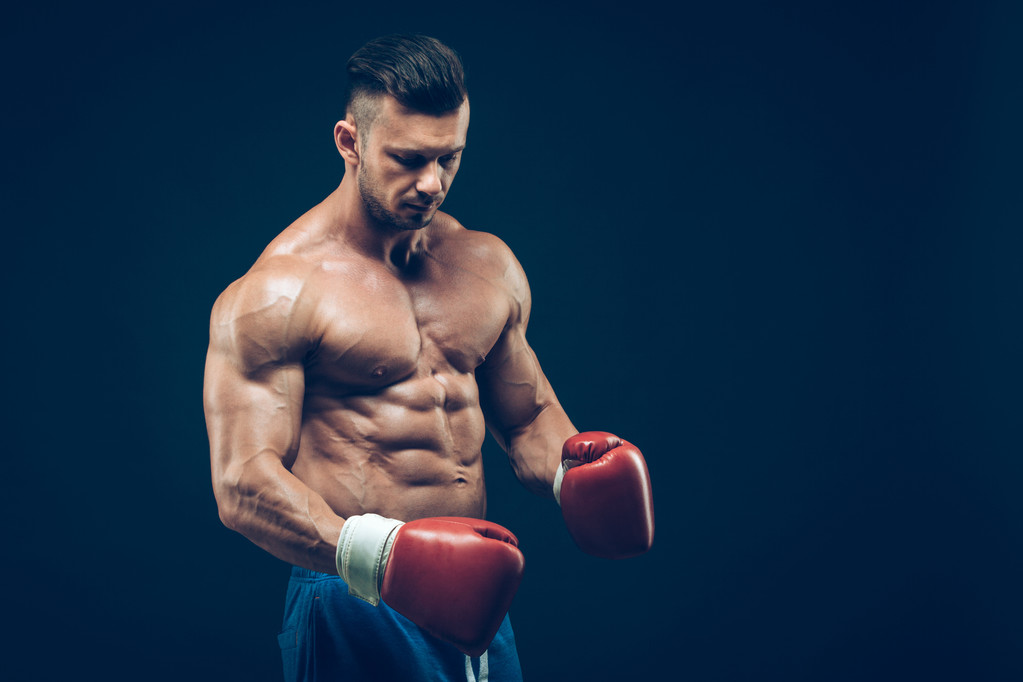 muskulöser Boxer im Studio, auf schwarzem Hintergrund. - Foto, Bild