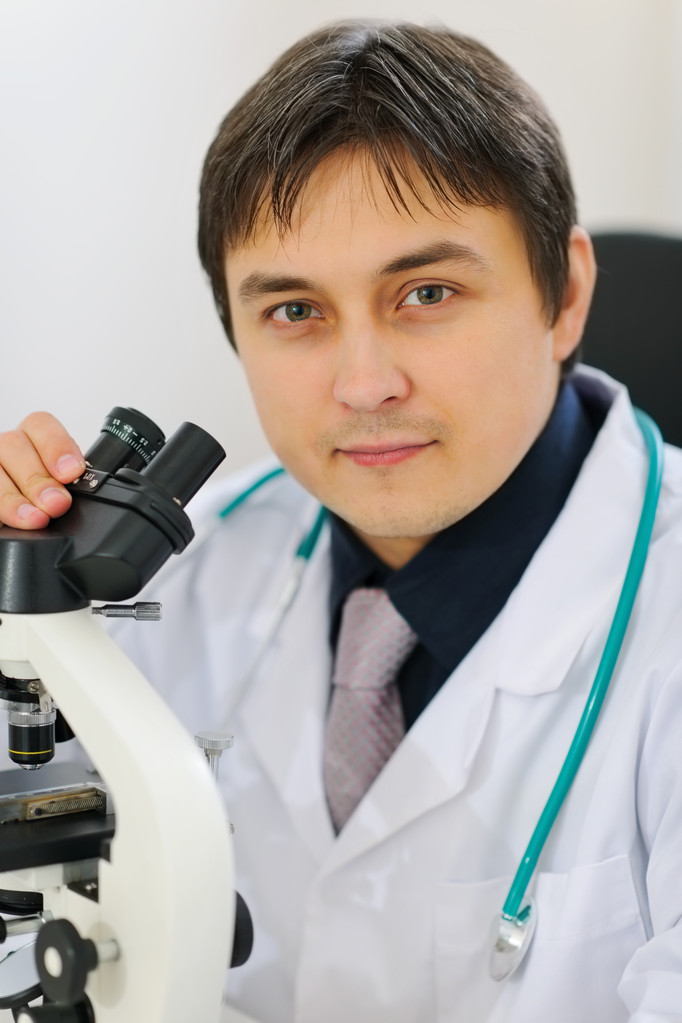 顕微鏡で働いている男性研究者の肖像画 - 写真・画像