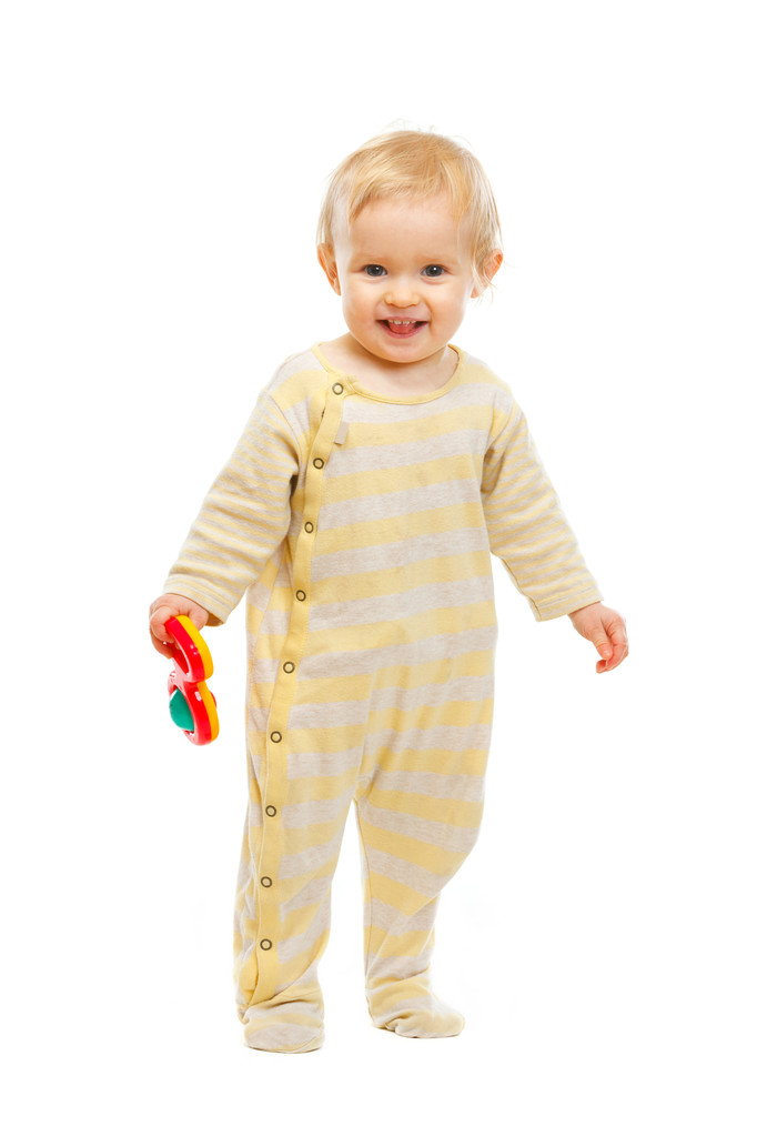 Sonriente niño de pie con sonajero sobre fondo blanco
 - Foto, Imagen
