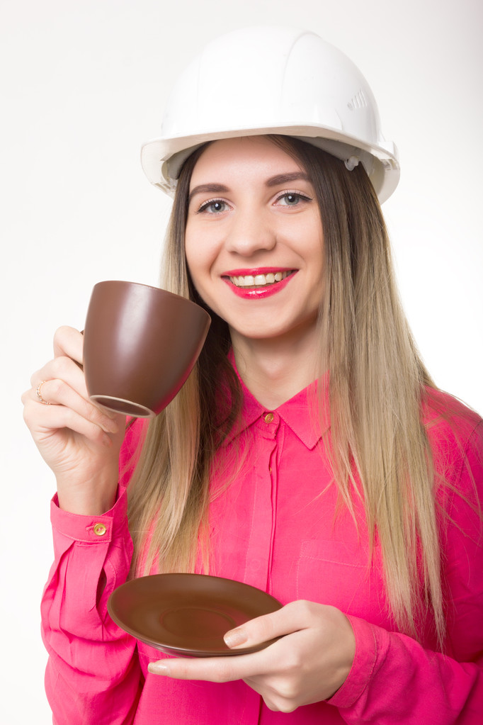 schöne Bauingenieurin mit Entwürfen. junge Architektin trinkt Kaffee aus einer braunen Tasse - Foto, Bild