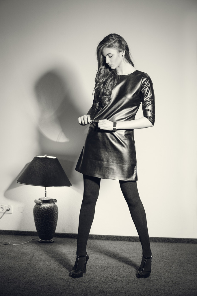 Jovem mulher sedutora em um vestido de couro preto
 - Foto, Imagem