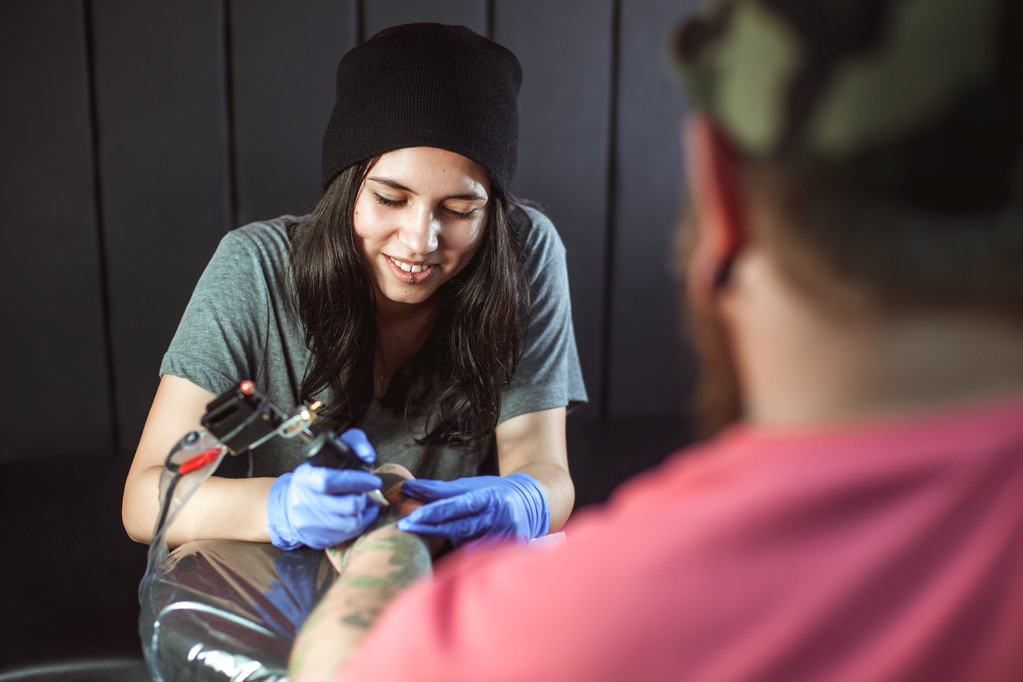 Beautiful brunette girl makes tattoo - Photo, Image