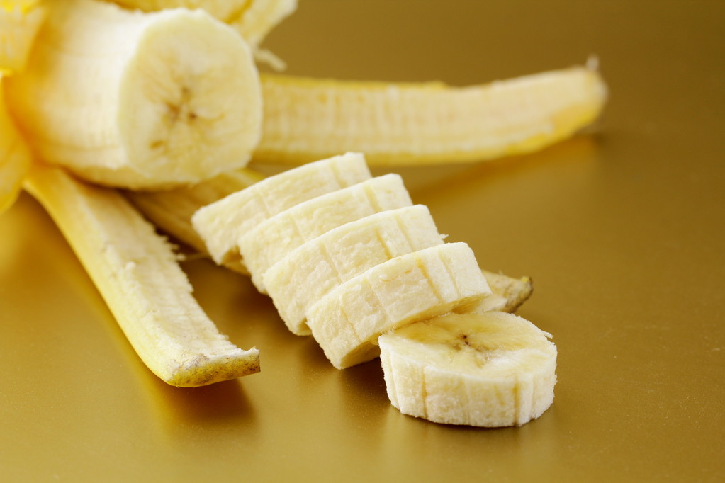 μπανάνες, κομμένες σε φέτες σε χρυσό φόντο - Φωτογραφία, εικόνα