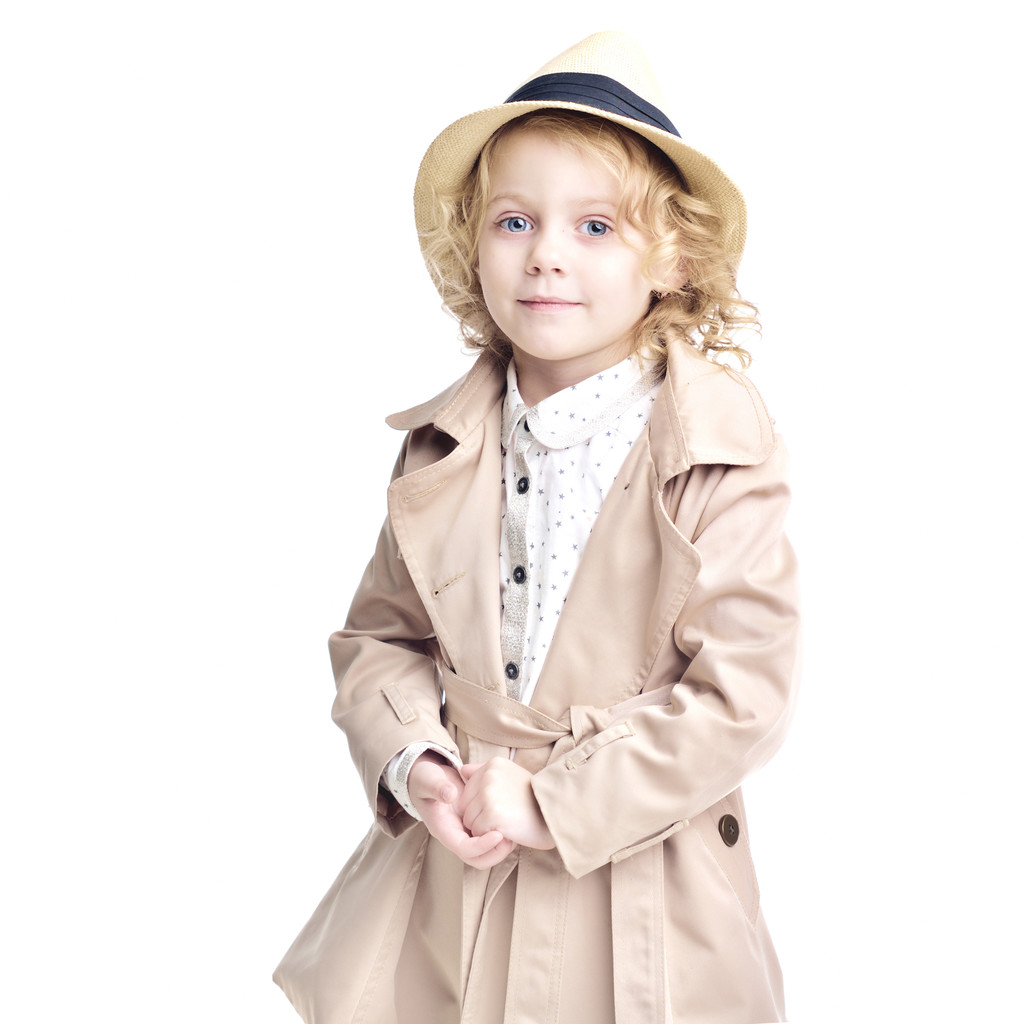 Modieuze kind. Blond meisje in een stijlvolle regenjas en hoed. - Foto, afbeelding