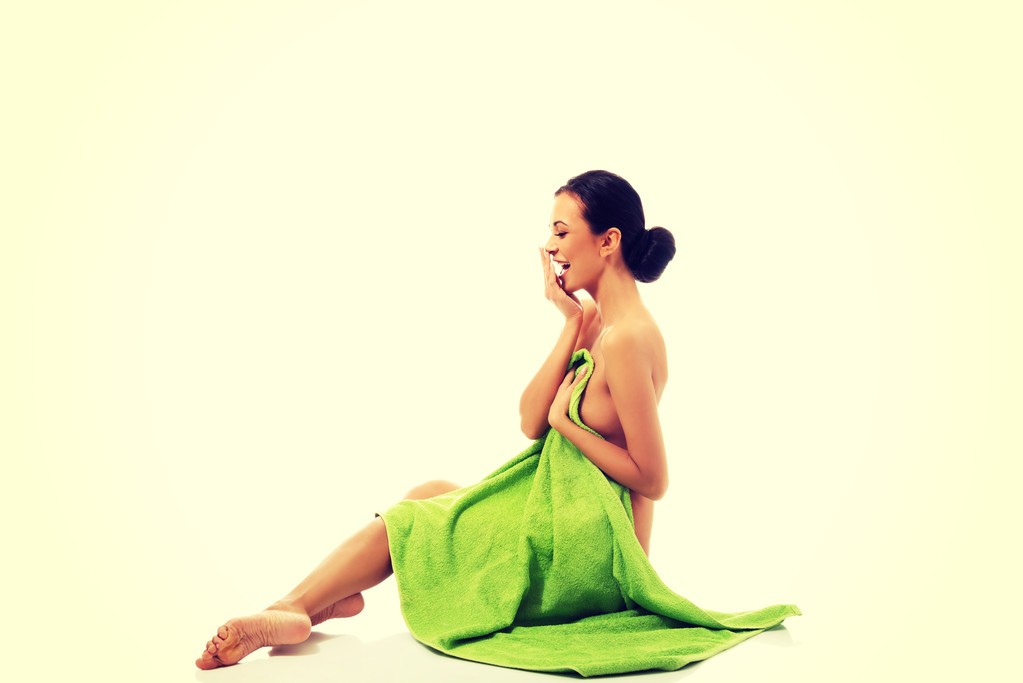 Rindo mulher sentado envolto em toalha
 - Foto, Imagem
