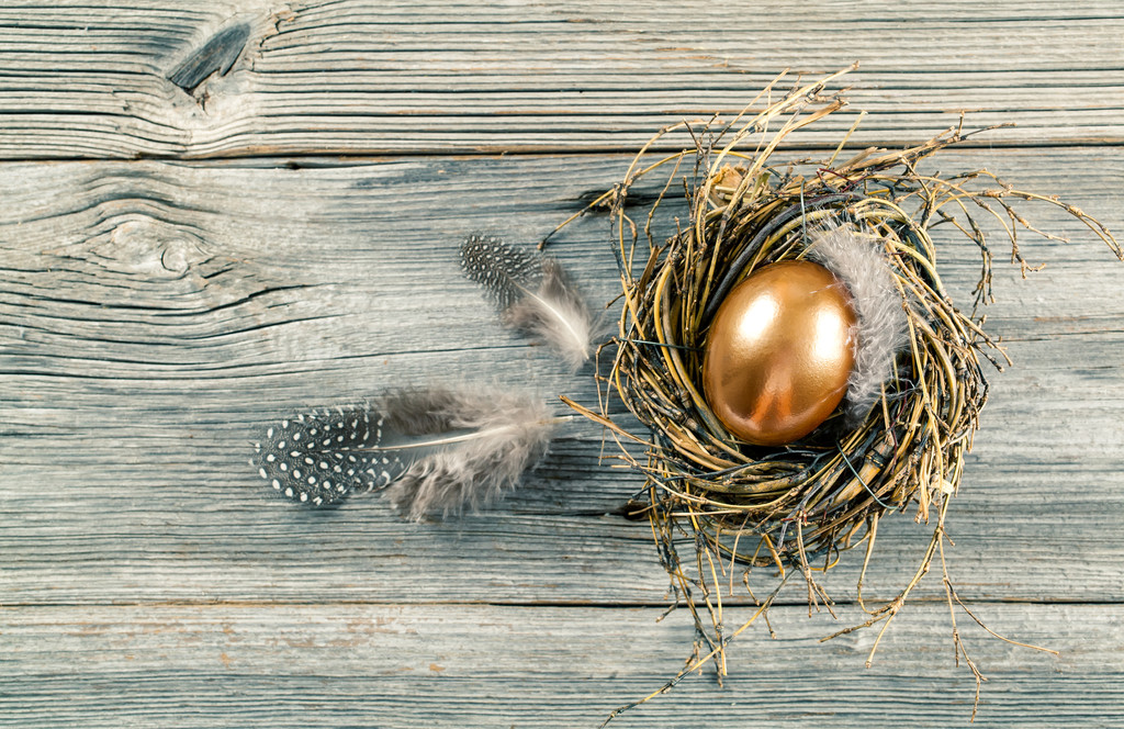 Złote jaja w gnieździe na ciemne tło drewniane - Zdjęcie, obraz