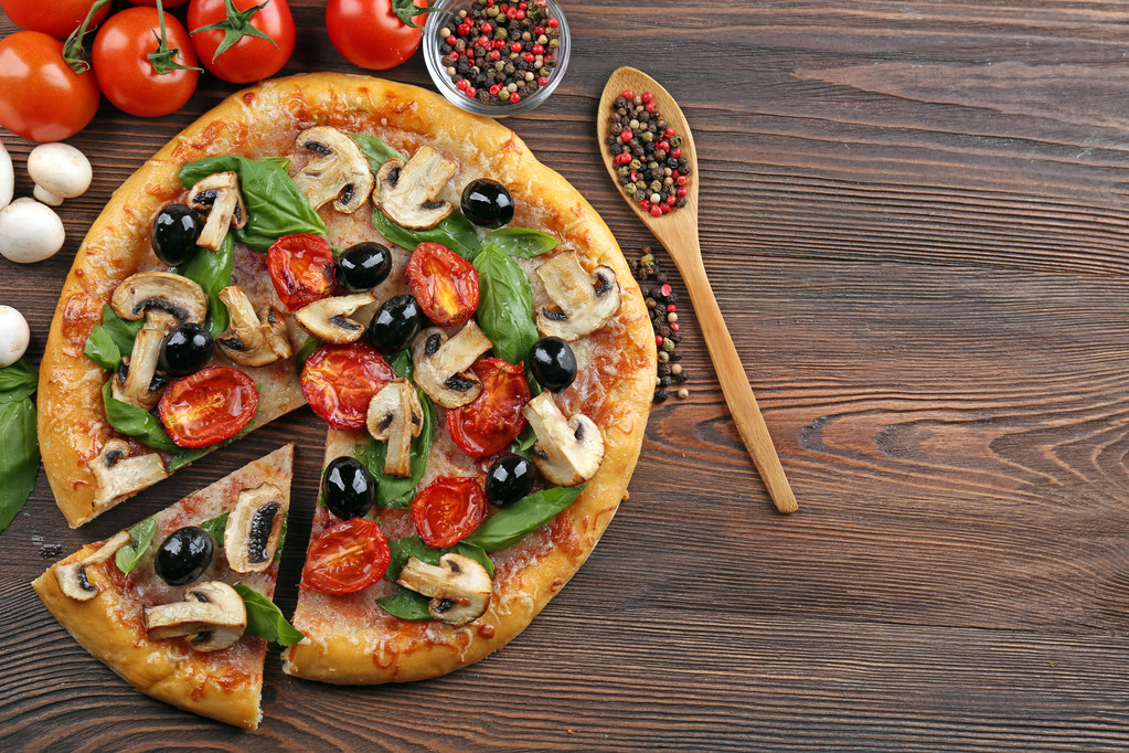 Pizza saborosa fatiada deliciosa com legumes na mesa de madeira
 - Foto, Imagem