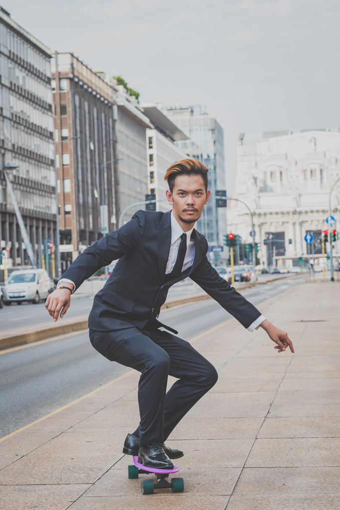 Jonge knappe Aziatische model zijn skateboard rijden - Foto, afbeelding