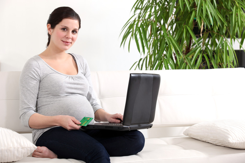 Pregnant woman sat on couch shopping on-line - Photo, Image