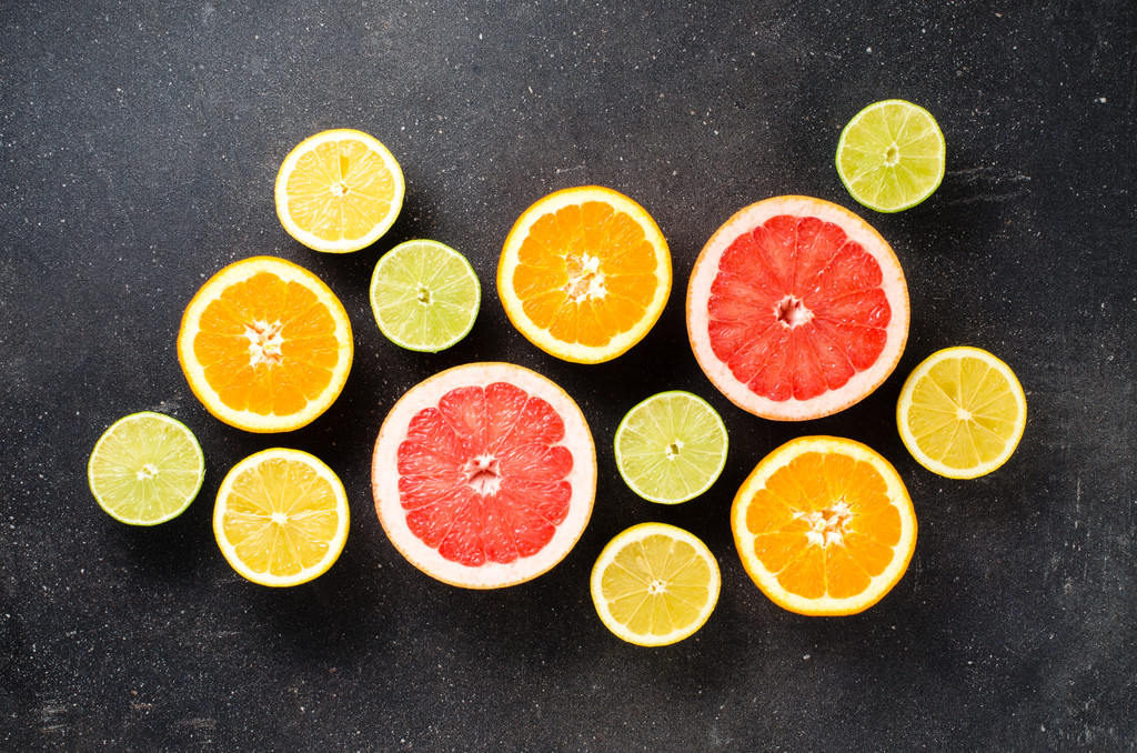 ダークウッドのテーブルに柑橘系の果物のミックス - 写真・画像