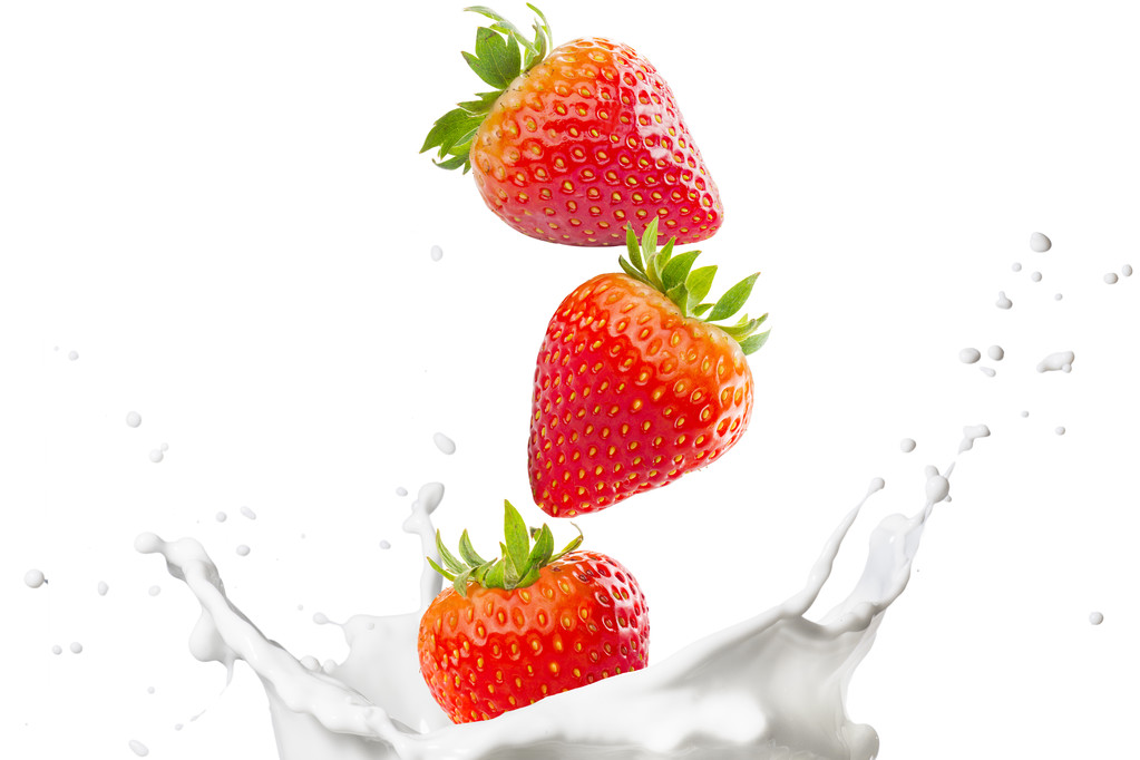 Fresas cayendo en el chorro de leche
 - Foto, imagen