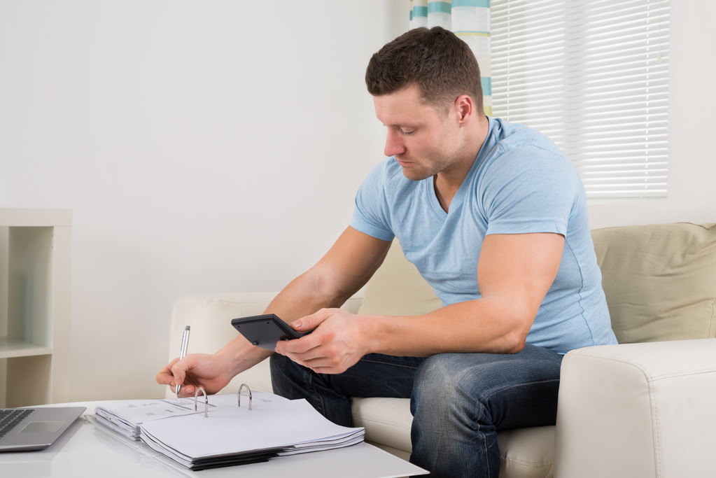 Hombre calculando presupuesto en casa
 - Foto, Imagen
