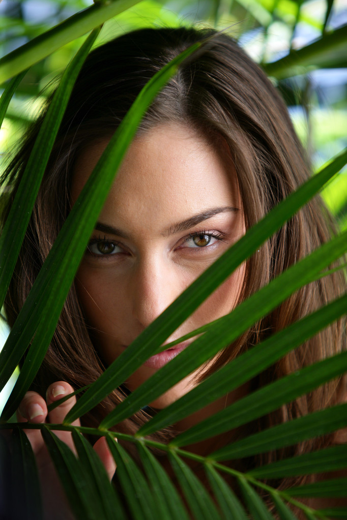 Femme se cachant derrière les feuilles de la plante
 - Photo, image