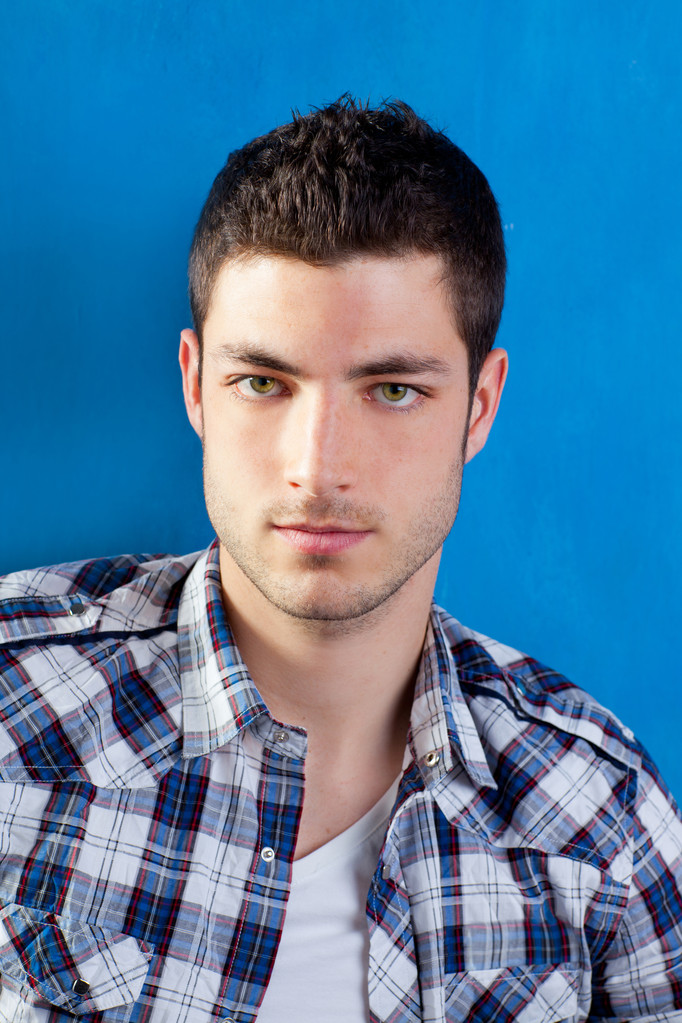 Красивый молодой человек в клетчатой рубашке на голубой
 - Фото, изображение