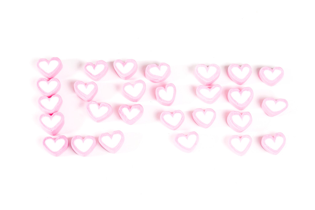 слово любов з рожевих цукерок ізольовані на білому
 - Фото, зображення