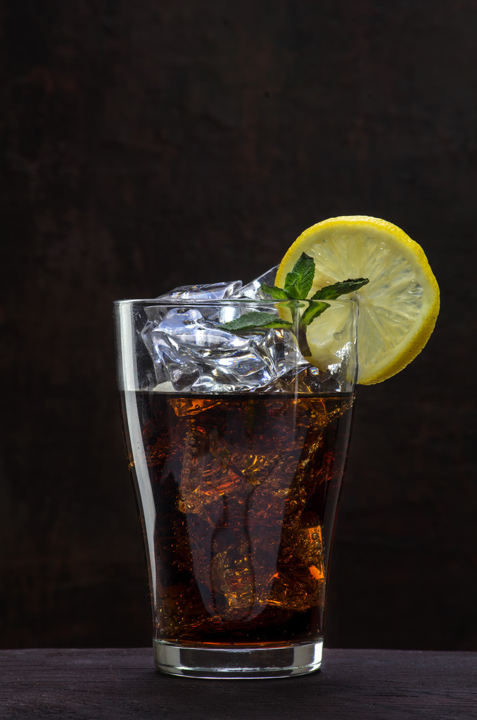 glas cola of coke met ijsblokjes, segment van de citroen en pepermunt - Foto, afbeelding
