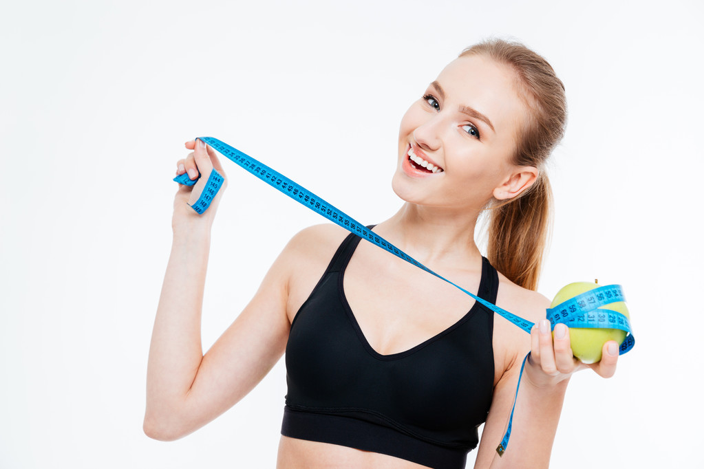 Veselá atraktivní sportovkyně drží jablko s měřicí páska  - Fotografie, Obrázek