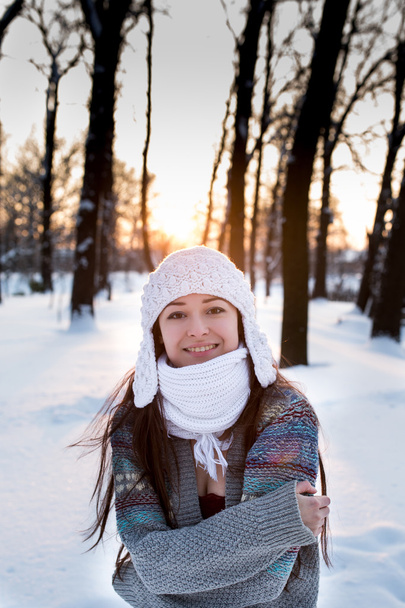 attractive young woman (Girl) playing with snow in warm clothing smiling in the Park - Фото, изображение