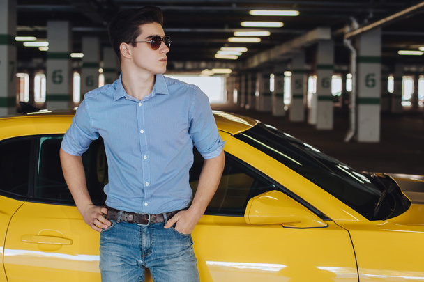 Handsome man standing near the modern sport car - Fotó, kép