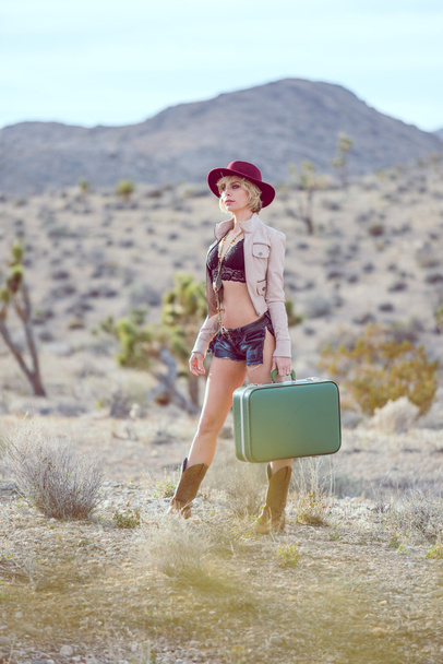 woman traveler walking with suitcase in desert - Foto, Imagem