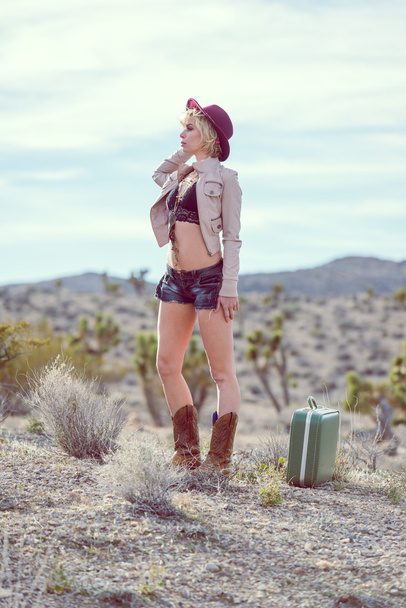 woman traveler walking with suitcase in desert - Fotó, kép