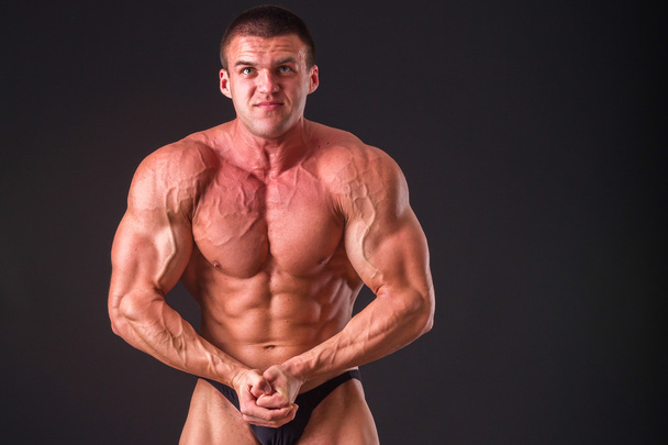 Bodybuilder που θέτουν σε διαφορετικές πόζες που αποδεικνύουν τους μυς. - Φωτογραφία, εικόνα