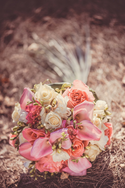 Bridal autumn bouquet with red and white roses over yellow autumn grass.  - Fotoğraf, Görsel