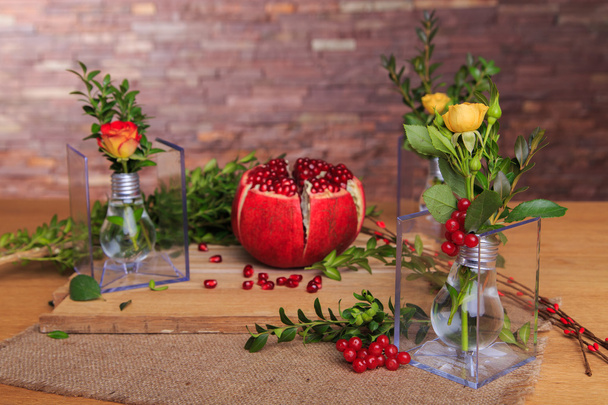Beautiful objective picture with pomegranate, roses, bulbs and herbs. - Photo, Image