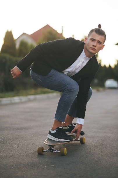 Image of a man with longboard going on road - Foto, Bild