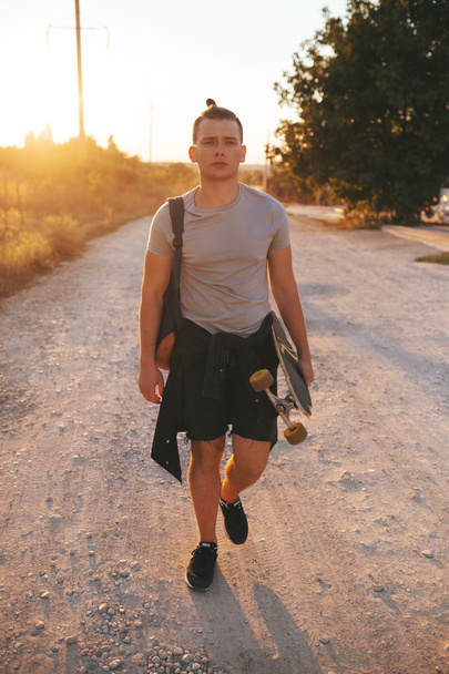 Immagine di un uomo con longboard che va su strada
 - Foto, immagini