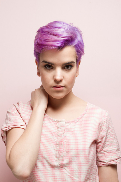Violet-short-haired woman in pink pastel holding her nape, indoo - Photo, Image