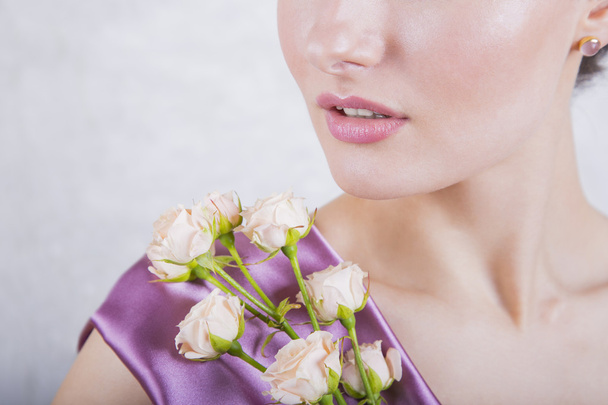 Part of beautiful young girl`s face with creamy roses bouquet - Foto, Imagem