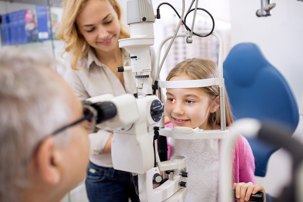 Mother and her daughter talk with eye specialist in clinic - 写真・画像