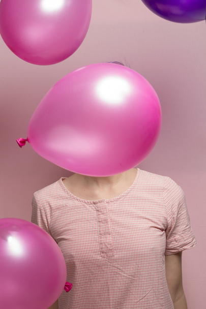 Violet short-haired woman in pink pastel, hiding behind falling  - Фото, изображение